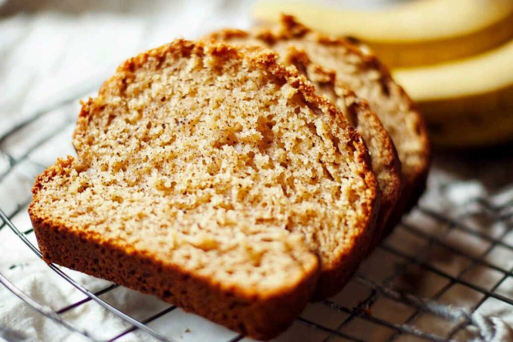 Slices of moist 4-ingredient banana bread on a cooling rack.