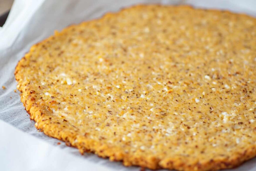 Gros plan d'une croûte de chou-fleur fraîchement cuite sur du papier sulfurisé.